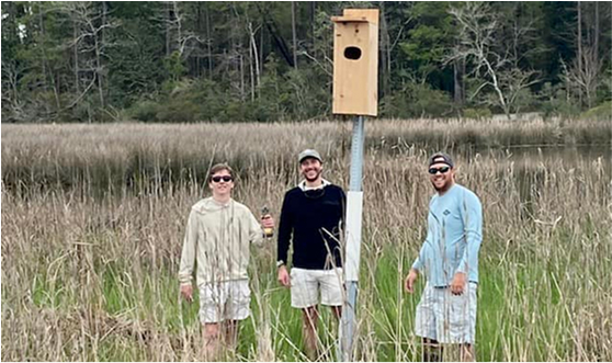 young men by a wood duck nesting box